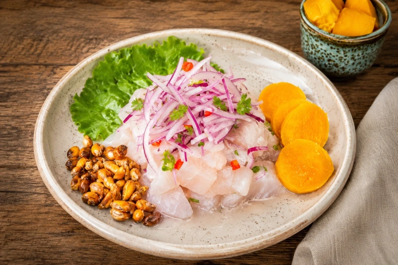 plato de ceviche de pescado con cancha serrana, camote, choclo y lechuga
