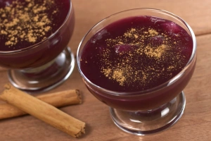 Mazamorra morada en copas de vidrio con canela espolvoreada y frutas frescas