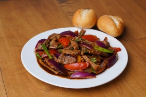 Plato de lomito al jugo acompañado de pan francés